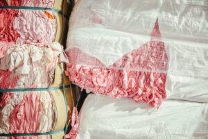 Fardos de residuos textiles rosas reciclados en la planta de Coleo para su reutilización circular